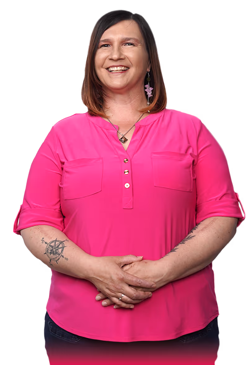 brunette woman smiling with pink earrings and matching blouse, she has a compass tattoo on her arm 