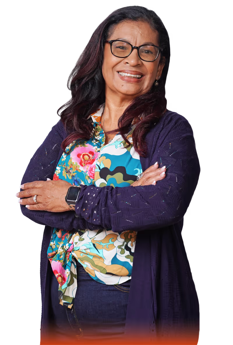 middle aged woman with glasses, navy blue sweater jacket, and colorful funky shirt smiling
