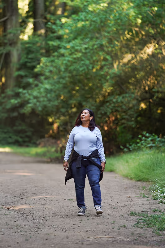 middle aged lady walking on an outdoor trail looking up into the sky