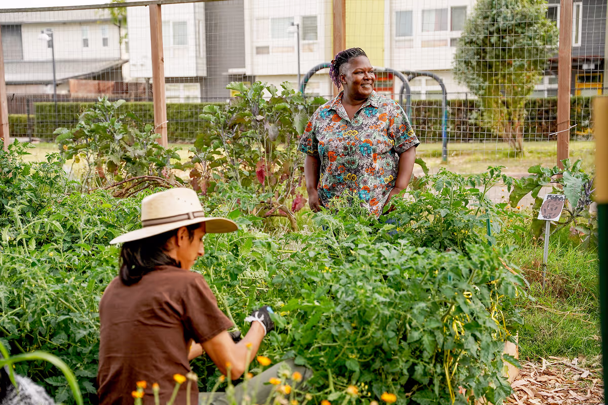 woman in floral shirt and back view of a man in the garden