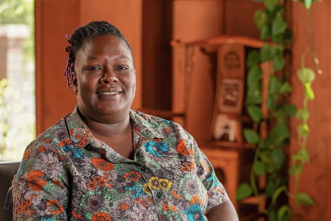 veteran female wearing a floral shirt in a calmly dim room