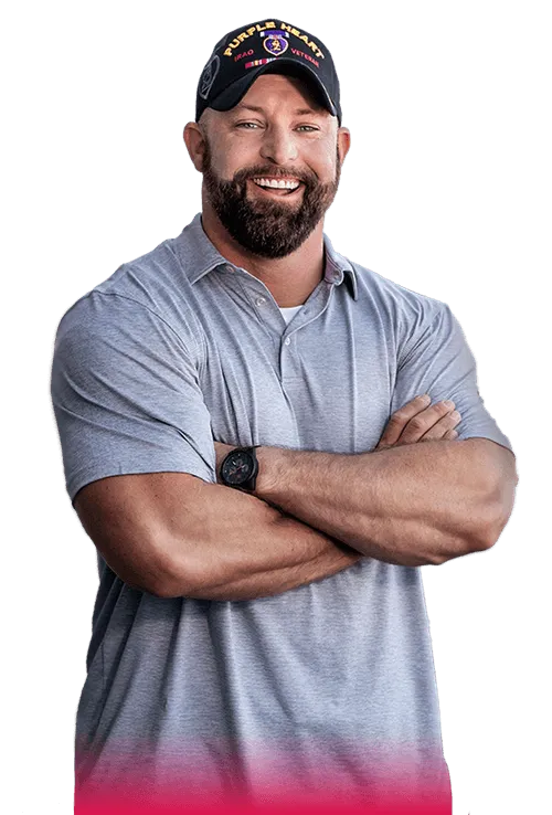 Veteran male standing with arms crossed wearing a purple heart Iraq veterans cap